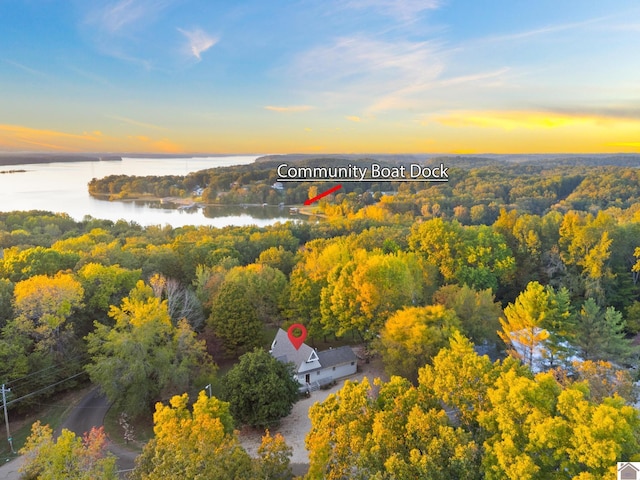 aerial view at dusk featuring a water view