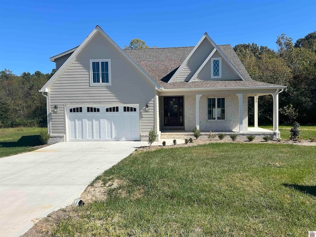 view of front of home featuring a front yard, covered porch, and a garage