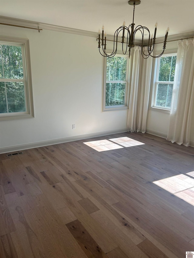 unfurnished dining area with hardwood / wood-style floors and an inviting chandelier