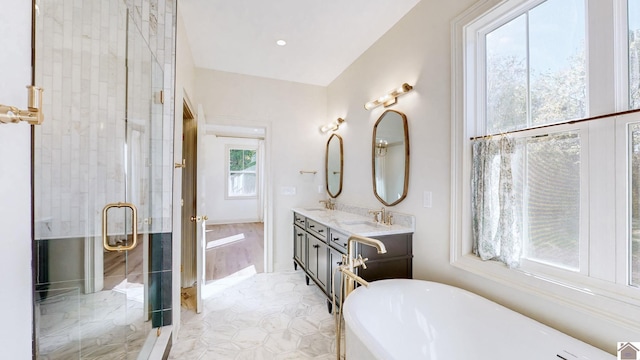 bathroom with vanity, plenty of natural light, and separate shower and tub