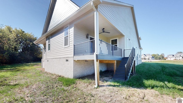 rear view of house with a lawn and ceiling fan