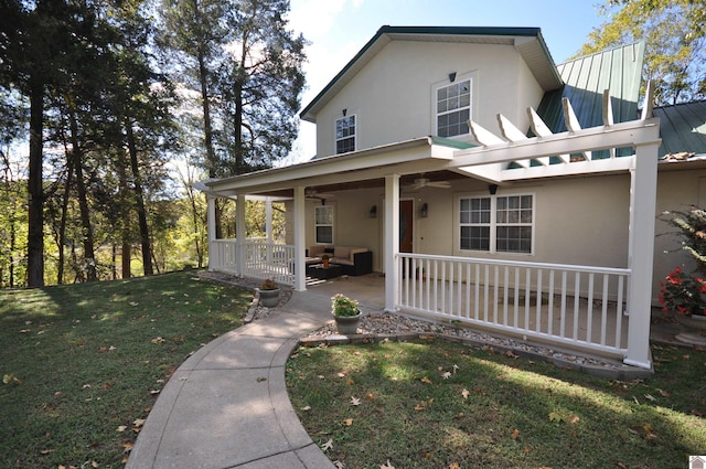 view of front of house with ceiling fan and a front yard