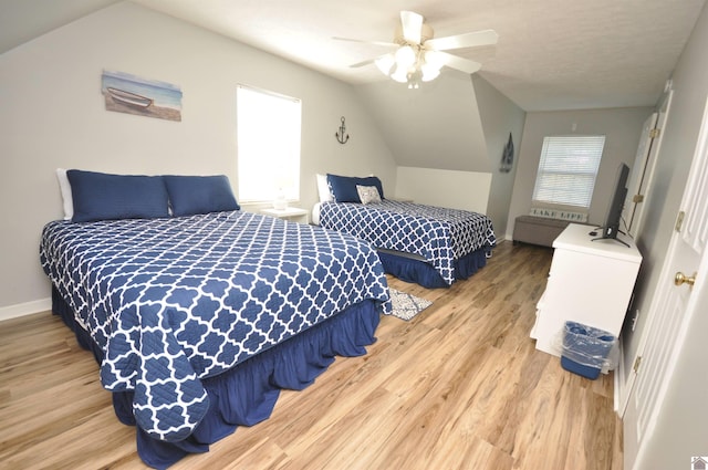 bedroom with ceiling fan, hardwood / wood-style flooring, and lofted ceiling