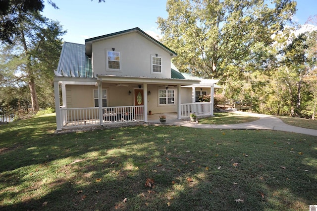 back of property with covered porch and a lawn