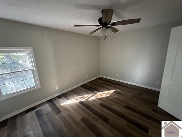 spare room featuring visible vents, wood finished floors, baseboards, and ceiling fan