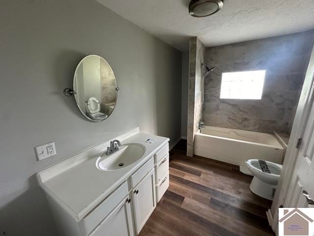 full bathroom with vanity, toilet, tiled shower / bath combo, and wood-type flooring