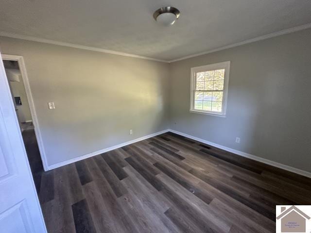 spare room featuring baseboards, ornamental molding, and dark wood-style flooring