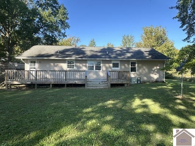 rear view of house featuring a lawn and a deck