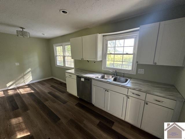 kitchen with white cabinets, stainless steel dishwasher, light countertops, and a sink