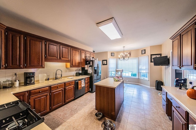 kitchen featuring appliances with stainless steel finishes, a center island, pendant lighting, a notable chandelier, and decorative backsplash