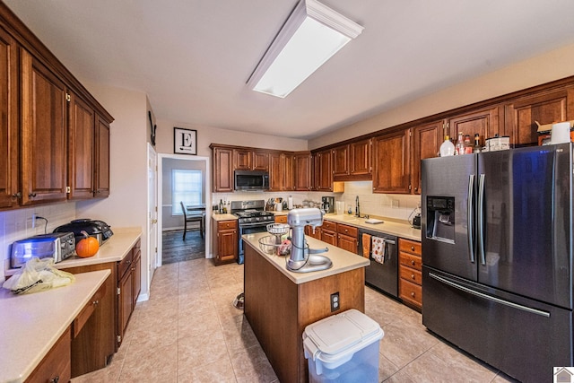 kitchen featuring appliances with stainless steel finishes, a center island, backsplash, and light tile patterned floors