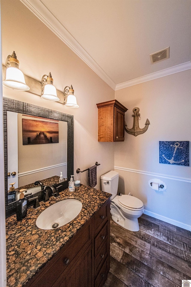 bathroom with vanity, toilet, wood-type flooring, and ornamental molding