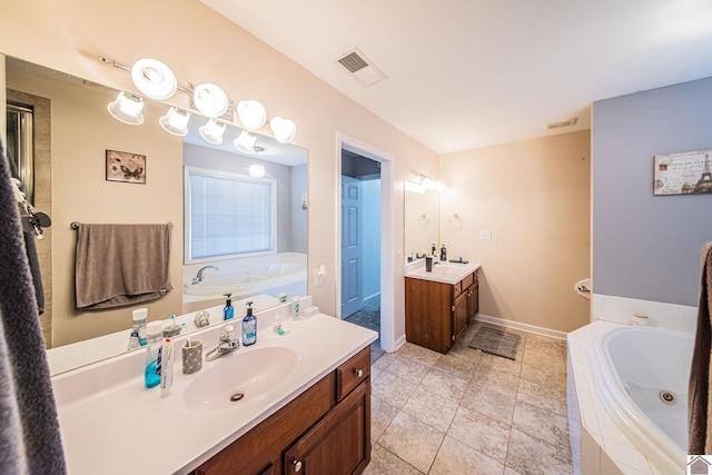 bathroom featuring vanity, tile patterned floors, and tiled bath