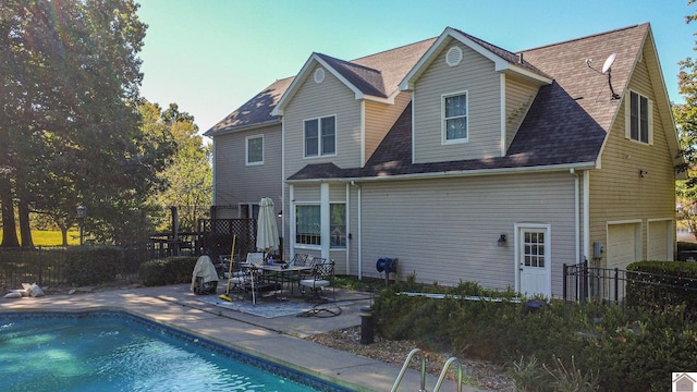 rear view of house with a patio and a fenced in pool