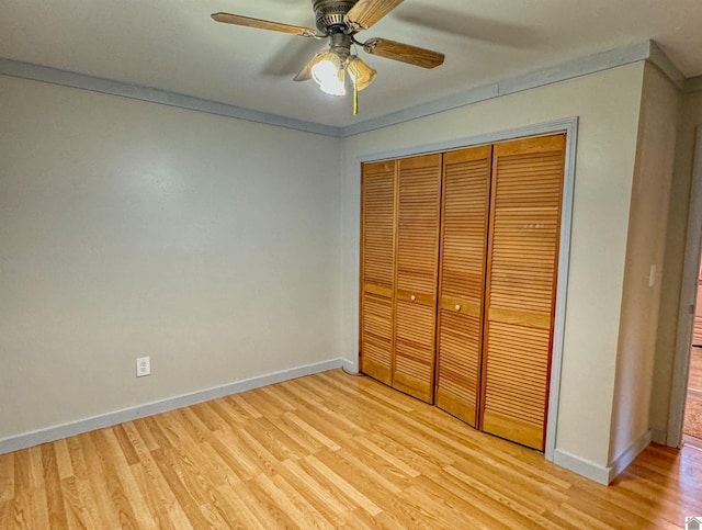 unfurnished bedroom featuring a closet, crown molding, light hardwood / wood-style floors, and ceiling fan