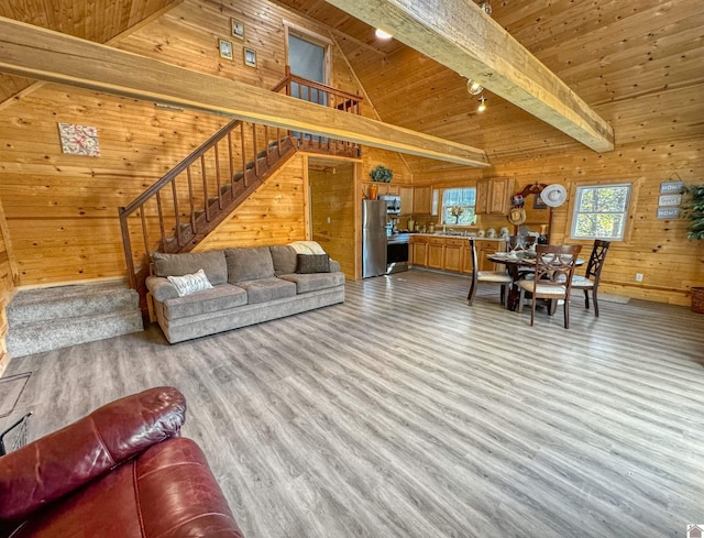 living room featuring wood ceiling, beam ceiling, high vaulted ceiling, light wood-type flooring, and wood walls