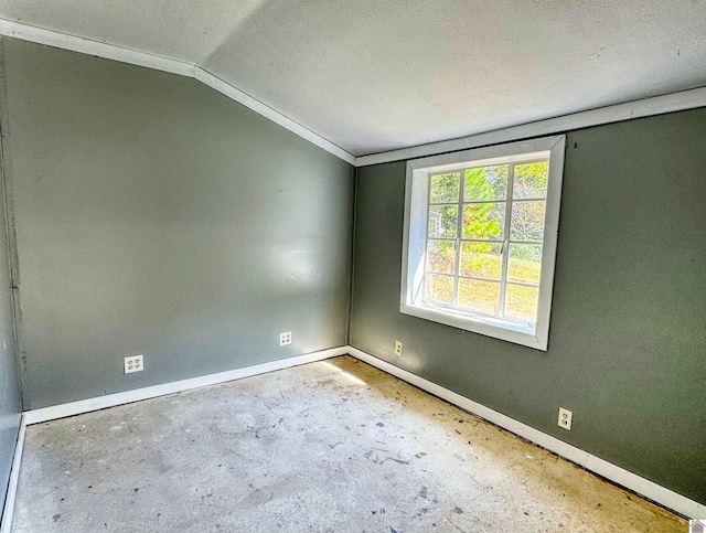 empty room with lofted ceiling and a textured ceiling