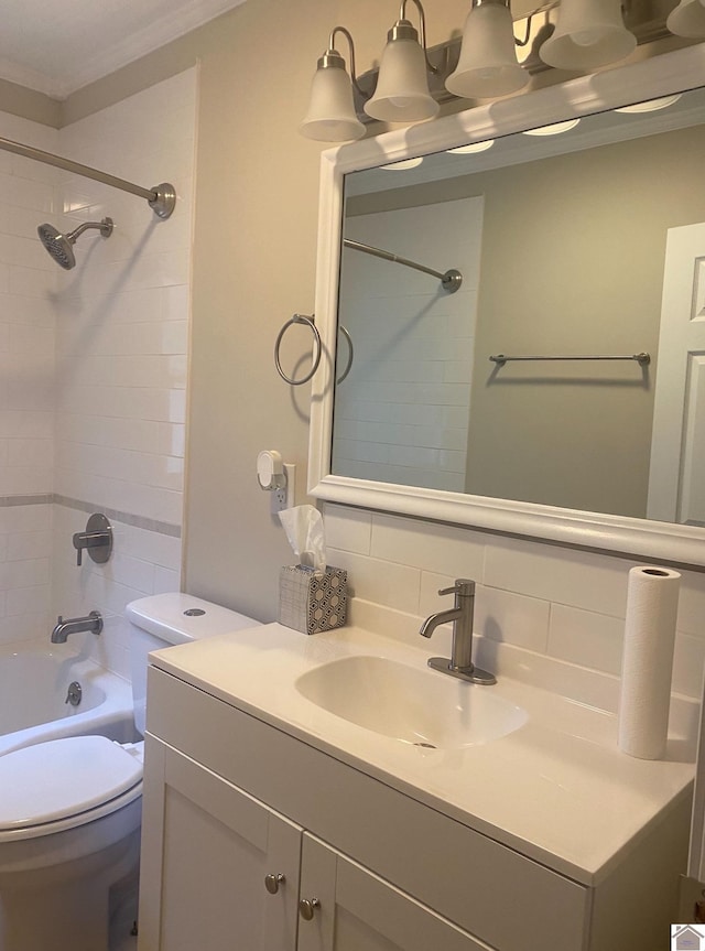 full bathroom with backsplash, toilet, vanity, crown molding, and tiled shower / bath combo