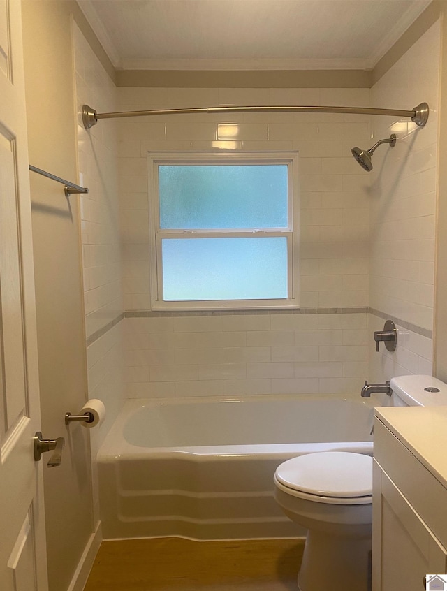 full bathroom with vanity, toilet, ornamental molding, and tiled shower / bath