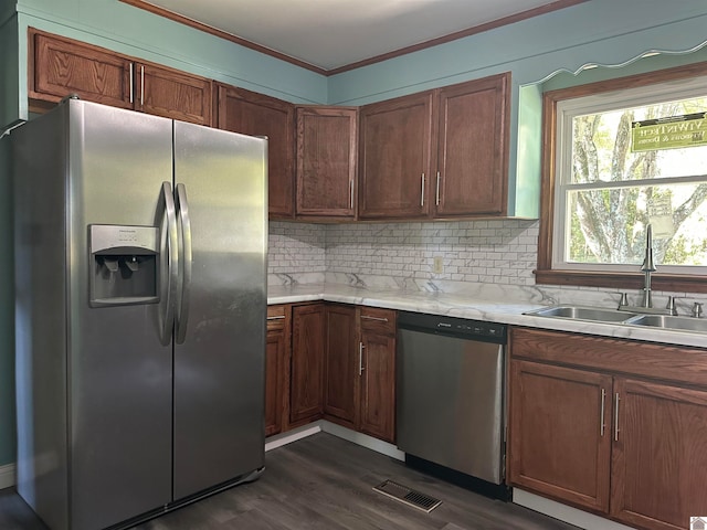 kitchen with appliances with stainless steel finishes, crown molding, sink, and dark hardwood / wood-style flooring