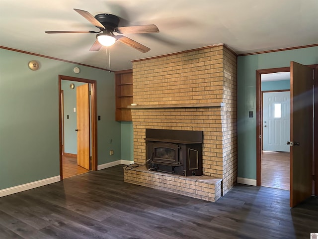 unfurnished living room with ceiling fan, ornamental molding, a wood stove, and dark hardwood / wood-style floors