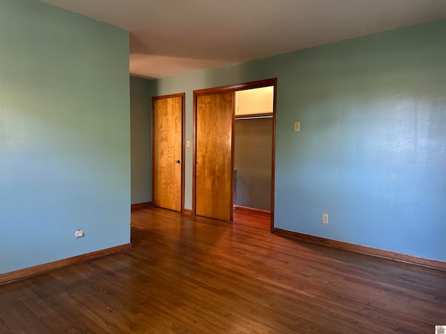 unfurnished bedroom with dark wood-type flooring