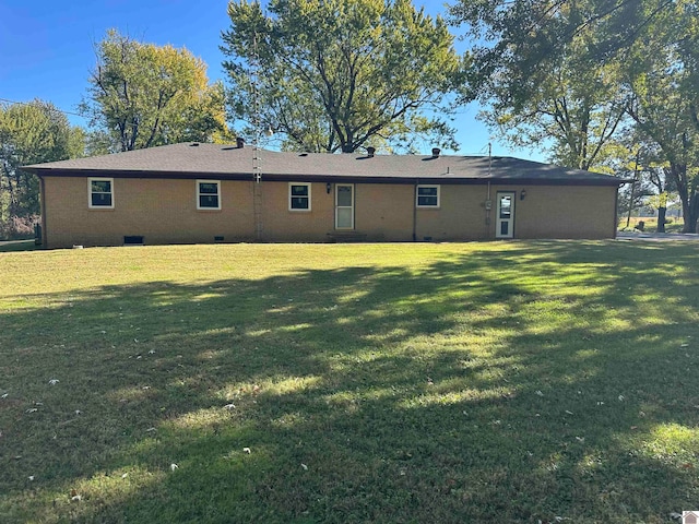 rear view of house featuring a lawn