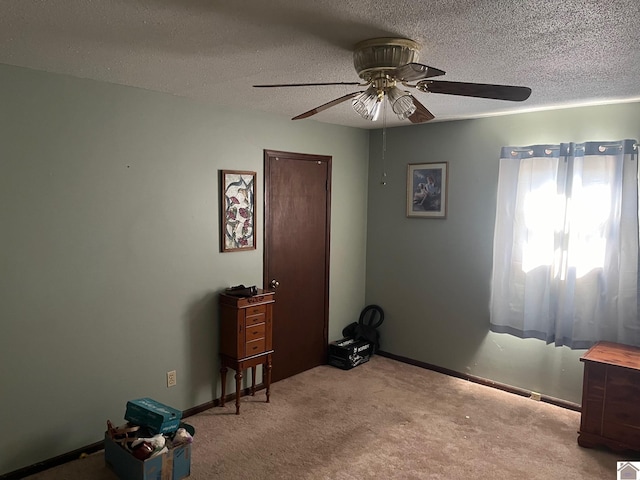 interior space with light carpet, a textured ceiling, and ceiling fan