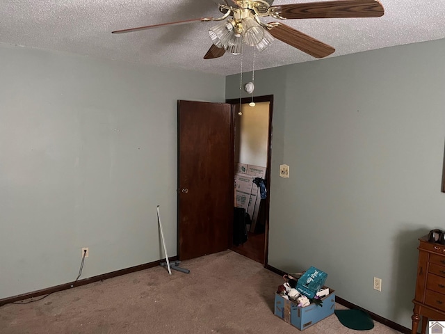 unfurnished bedroom with ceiling fan, light carpet, and a textured ceiling