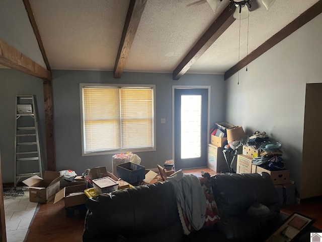 living room featuring ceiling fan, a textured ceiling, and vaulted ceiling with beams