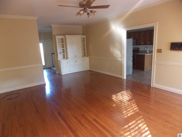 empty room with ornamental molding, sink, wood-type flooring, and ceiling fan