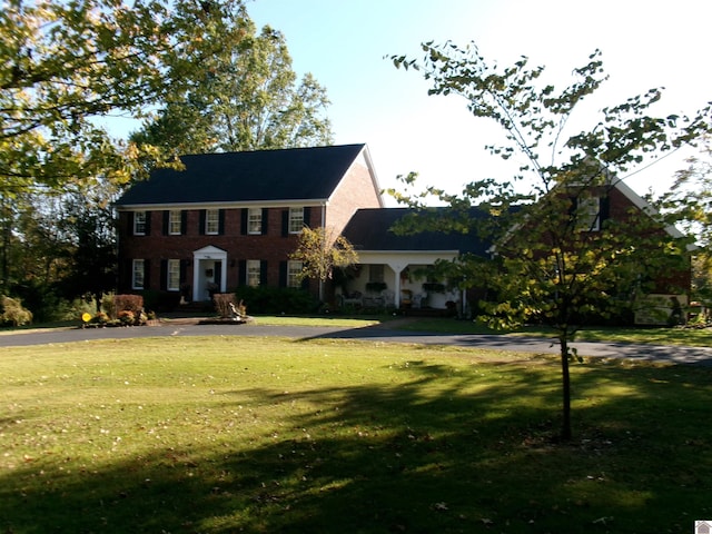 colonial-style house featuring a front lawn