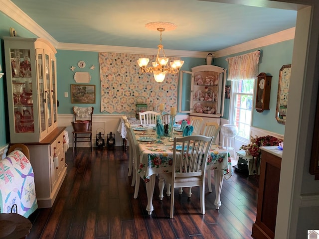 dining area with dark wood-type flooring, crown molding, and a chandelier