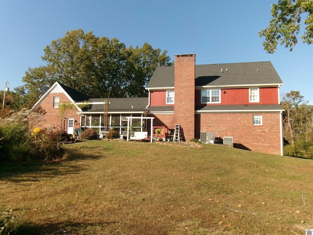 rear view of property featuring a sunroom and a lawn