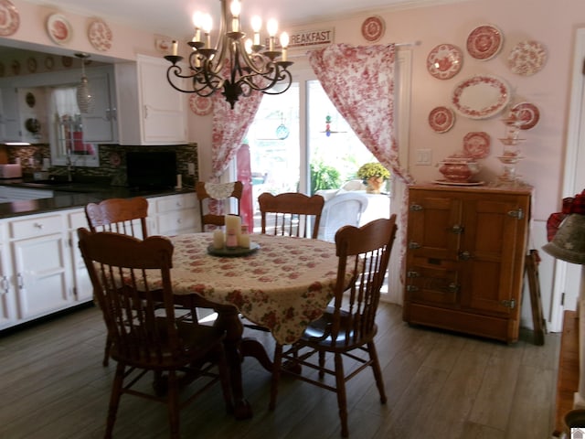 dining room featuring sink, crown molding, hardwood / wood-style flooring, and a chandelier