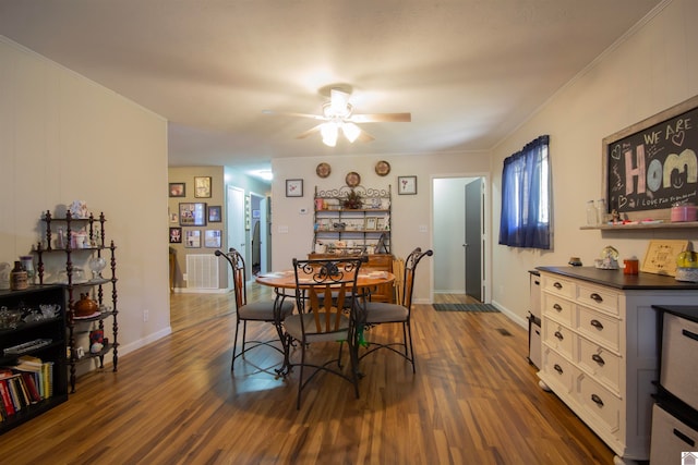 dining room with crown molding, dark hardwood / wood-style floors, and ceiling fan