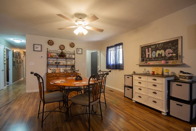 dining space featuring crown molding, dark wood-type flooring, and ceiling fan