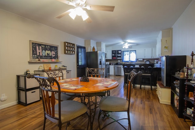 dining area with crown molding, dark wood-type flooring, and ceiling fan