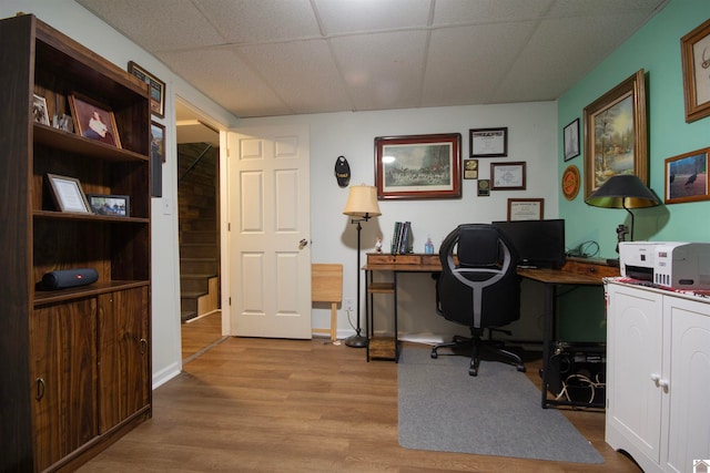 office area featuring a drop ceiling and light hardwood / wood-style flooring