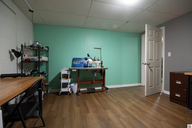 home office with a paneled ceiling and wood-type flooring