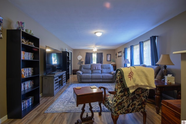 living room featuring wood-type flooring and ceiling fan