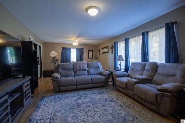 living room with dark wood-type flooring and ceiling fan