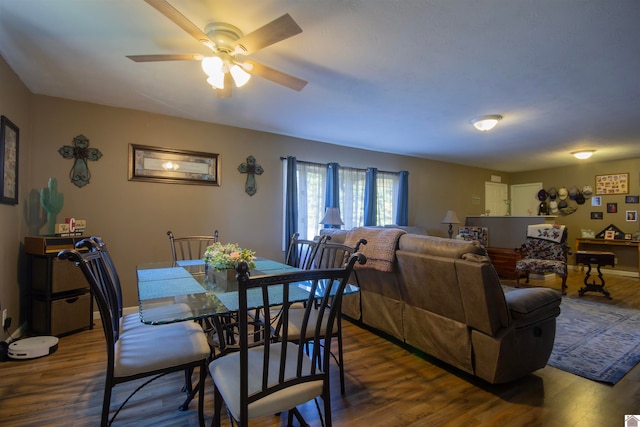 dining area with dark wood-type flooring and ceiling fan