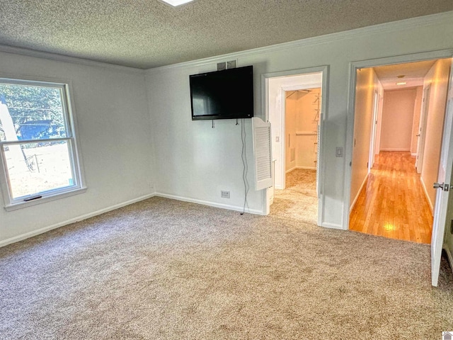 unfurnished bedroom featuring ornamental molding, light carpet, and a textured ceiling