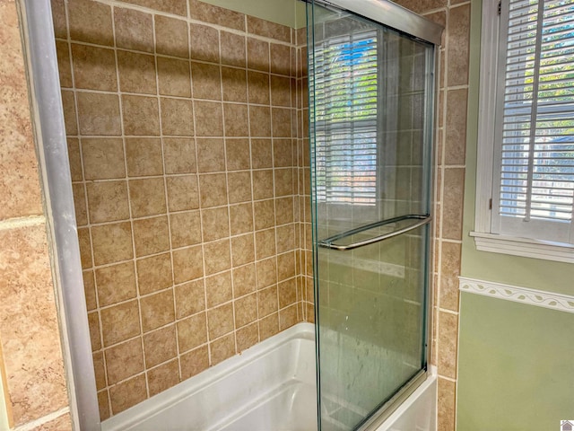 bathroom with shower / bath combination with glass door