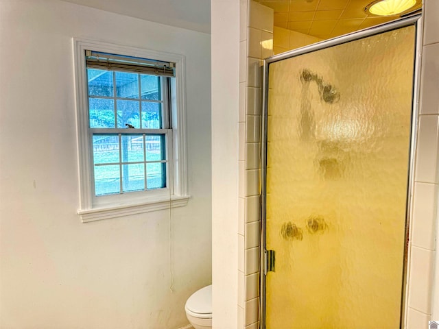 bathroom featuring toilet and an enclosed shower