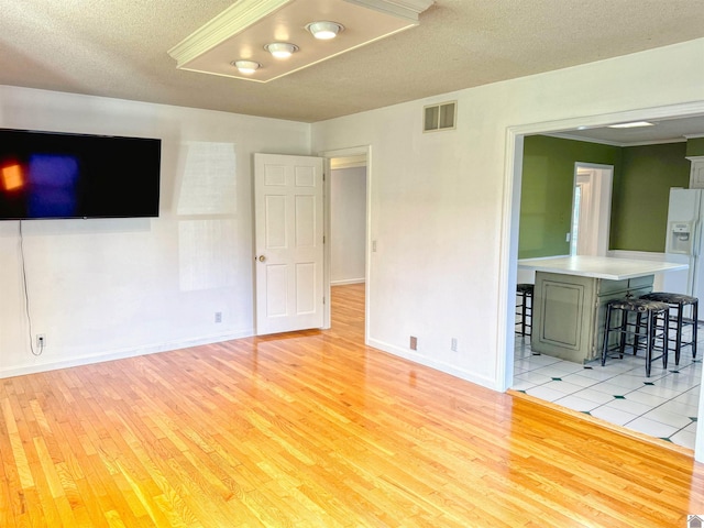 1516 Canterbury Dr, Murray, KY 42071 - unfurnished living room with light wood finished floors, baseboards, and a textured ceiling