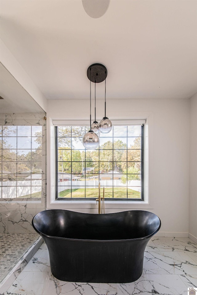 bathroom featuring a tub and a wealth of natural light