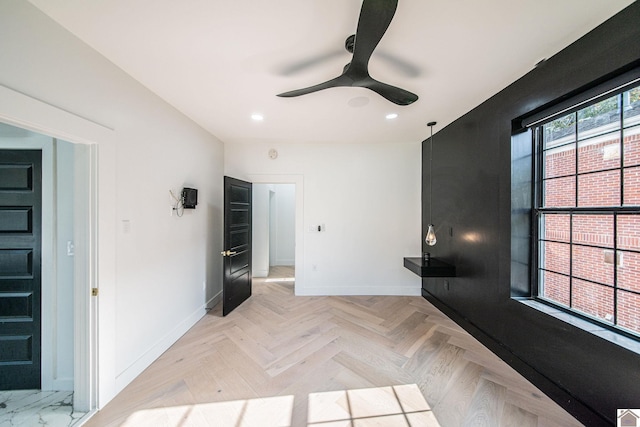 interior space with light parquet floors and ceiling fan