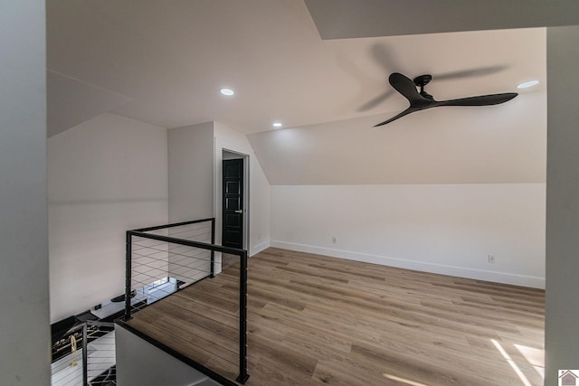 additional living space featuring vaulted ceiling, hardwood / wood-style flooring, and ceiling fan